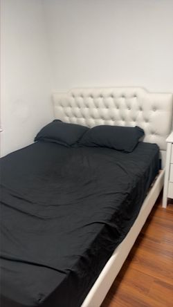 Queen-size bed with mattress and small cabinet