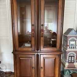 Curio cabinet with glass shelves and lights.