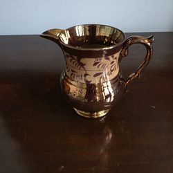 Copper lusterware pottery pitcher with hand-painted floral band decoration