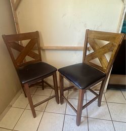 2 Wooden X-Back Stools with cushioned black seats.