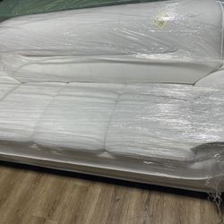 Brand new white sofa wrapped in plastic.