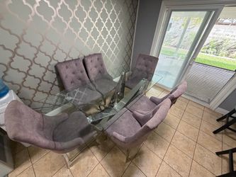 Modern Glam Glass Dining Table with a Geometric Chrome Base and 6 Mauve Velvet Upholstered Chairs.