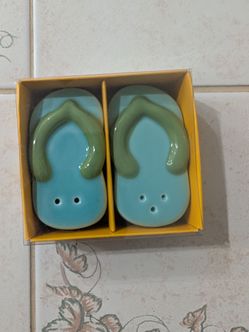 This is a Nora Fleming "Sunning & Funning" flip-flop mini decorative piece in light blue and green.