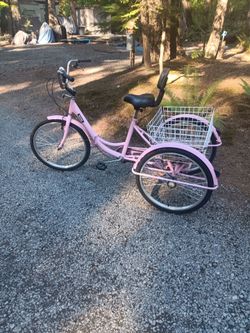 pink 3 wheel bike with basket and it folds up