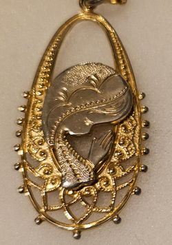 14k Gold Filled Praying Hands Vintage Medallion, it's Not Solid Gold. It's similar to plated.