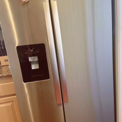 Whirlpool side-by-side refrigerator with a stainless steel finish and an exterior ice and water dispenser. 