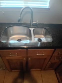 Double kitchen sink with marble countertop and bottom Cabinets