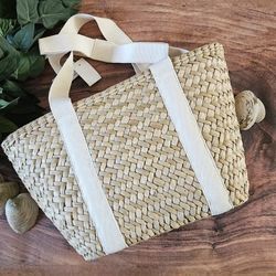 J.Crew nwt straw tote bag with natural canvas straps and bow detail at shoulder approximately 11"h x 16 3/4"w with 9 1/2" drop handle
