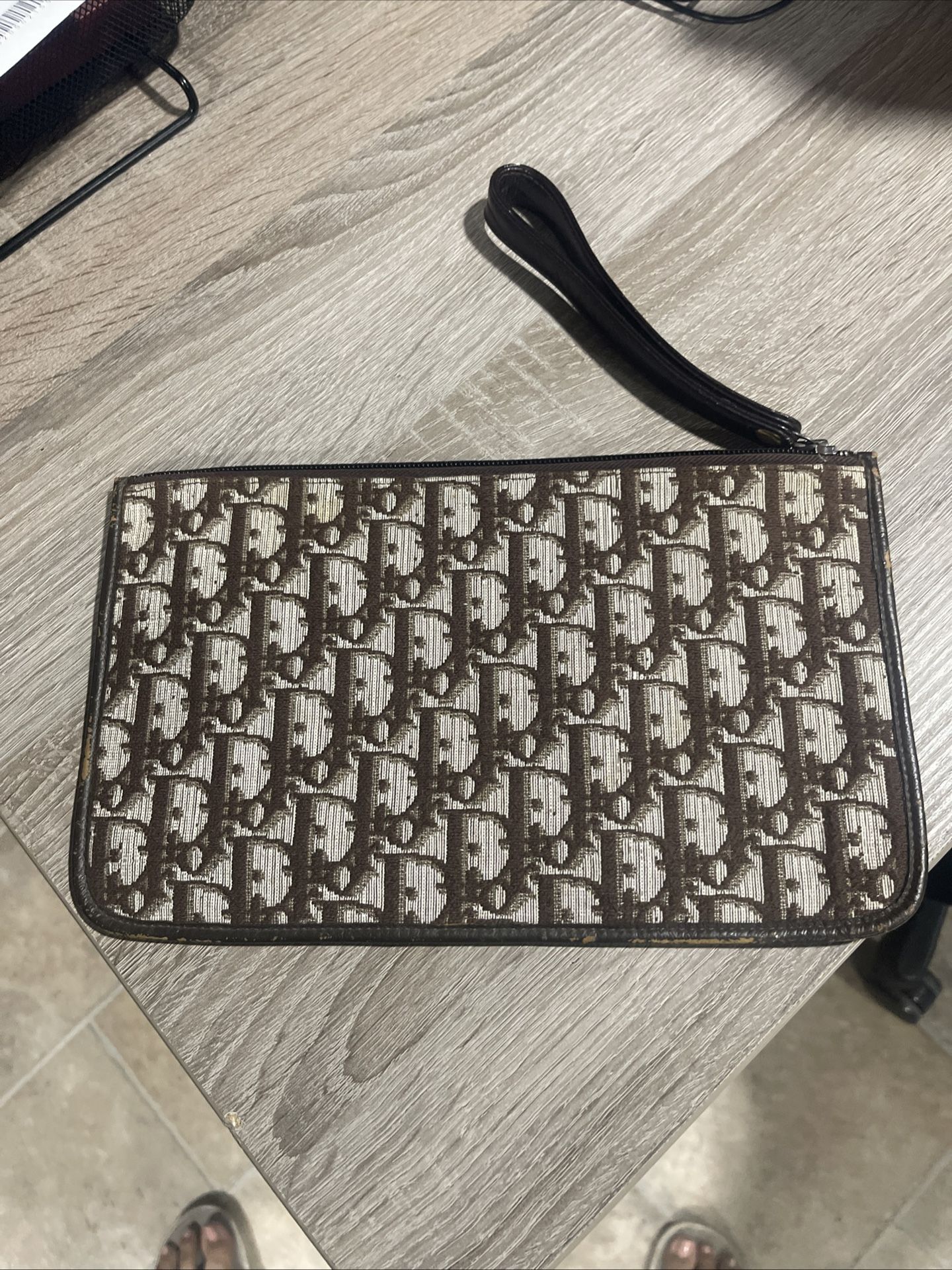 Oblique clutch bag with a brown logo on a beige background - Christian Dior logo