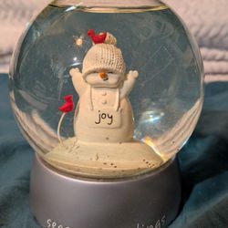 The Snow Globe Features A Snowman With Two Red Cardinal Birds.