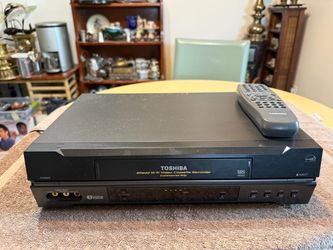 Black Toshiba W522 4-head Hi-Fi video cassette recorder includes a matching remote control. The front panel has line-in audio and video ports, channel