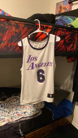 Two Lakers jerseys , bulls jerseys, and a raiders jersey