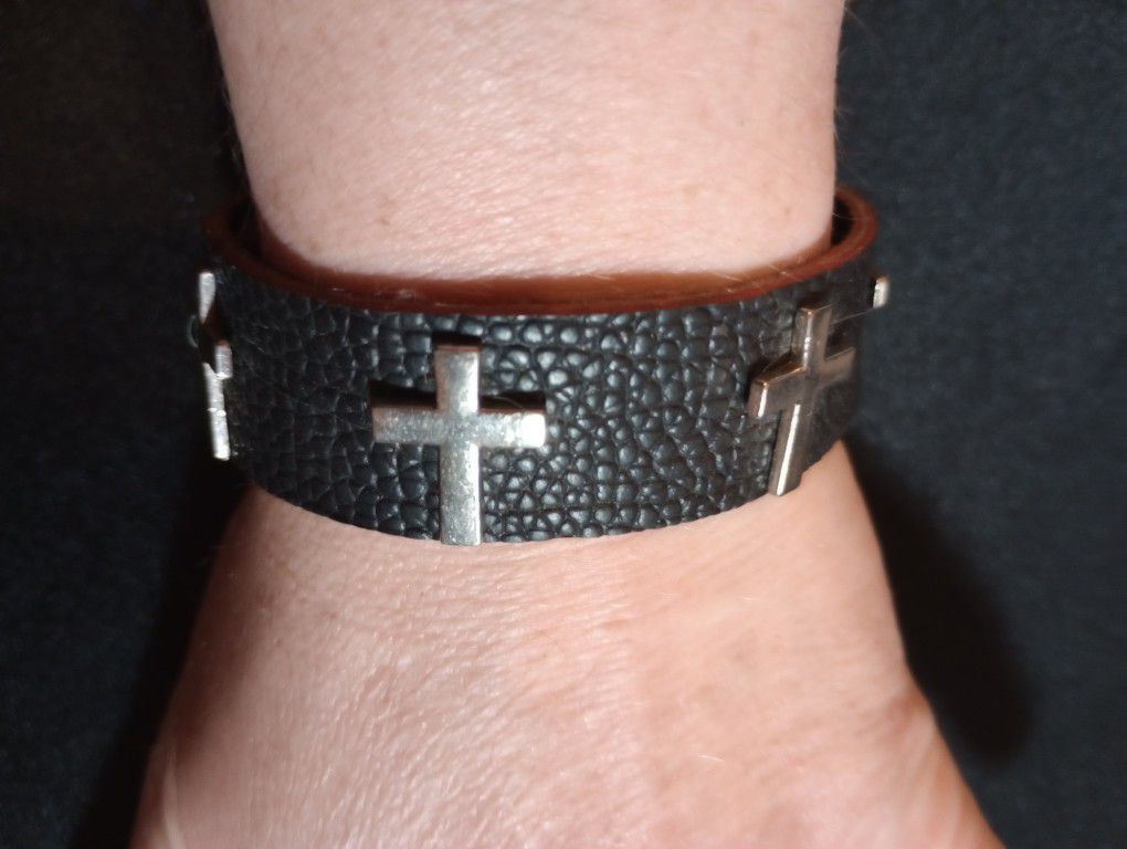 Black Leather Bracelet With Silver Crosses Going Around It 
