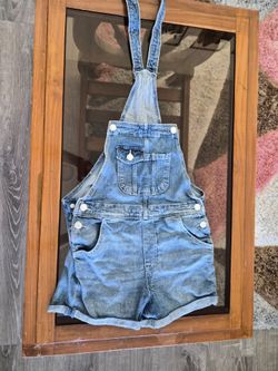 blue denim overalls for children with adjustable straps and a front pocket