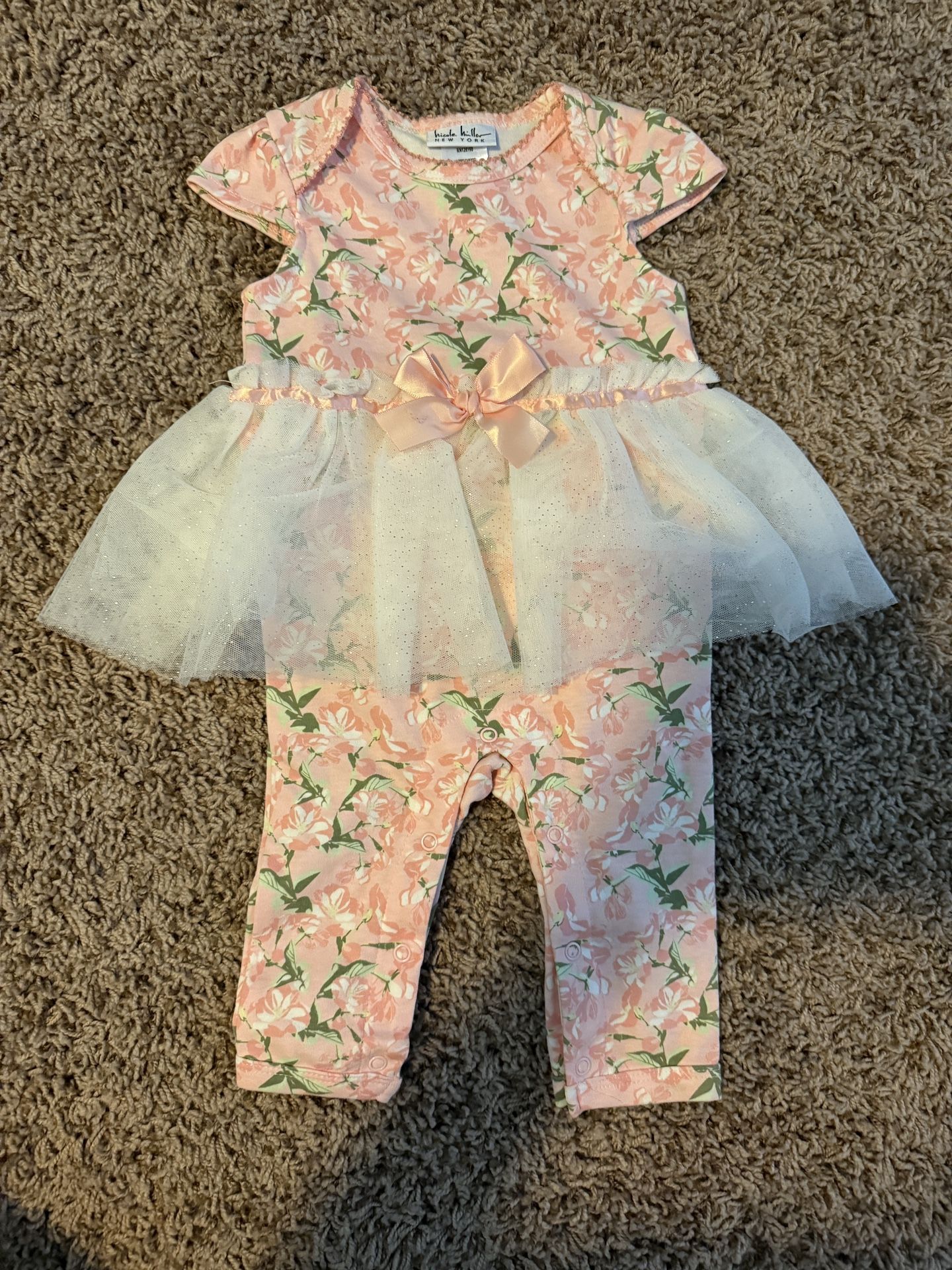 Pink floral infant outfit with attached tulle skirt and bow.