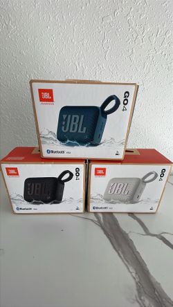 New JBL Go 4 portable Bluetooth speakers. Three speakers in different colors: blue, black, and white. Each speaker has Bluetooth V5.3 connectivity and