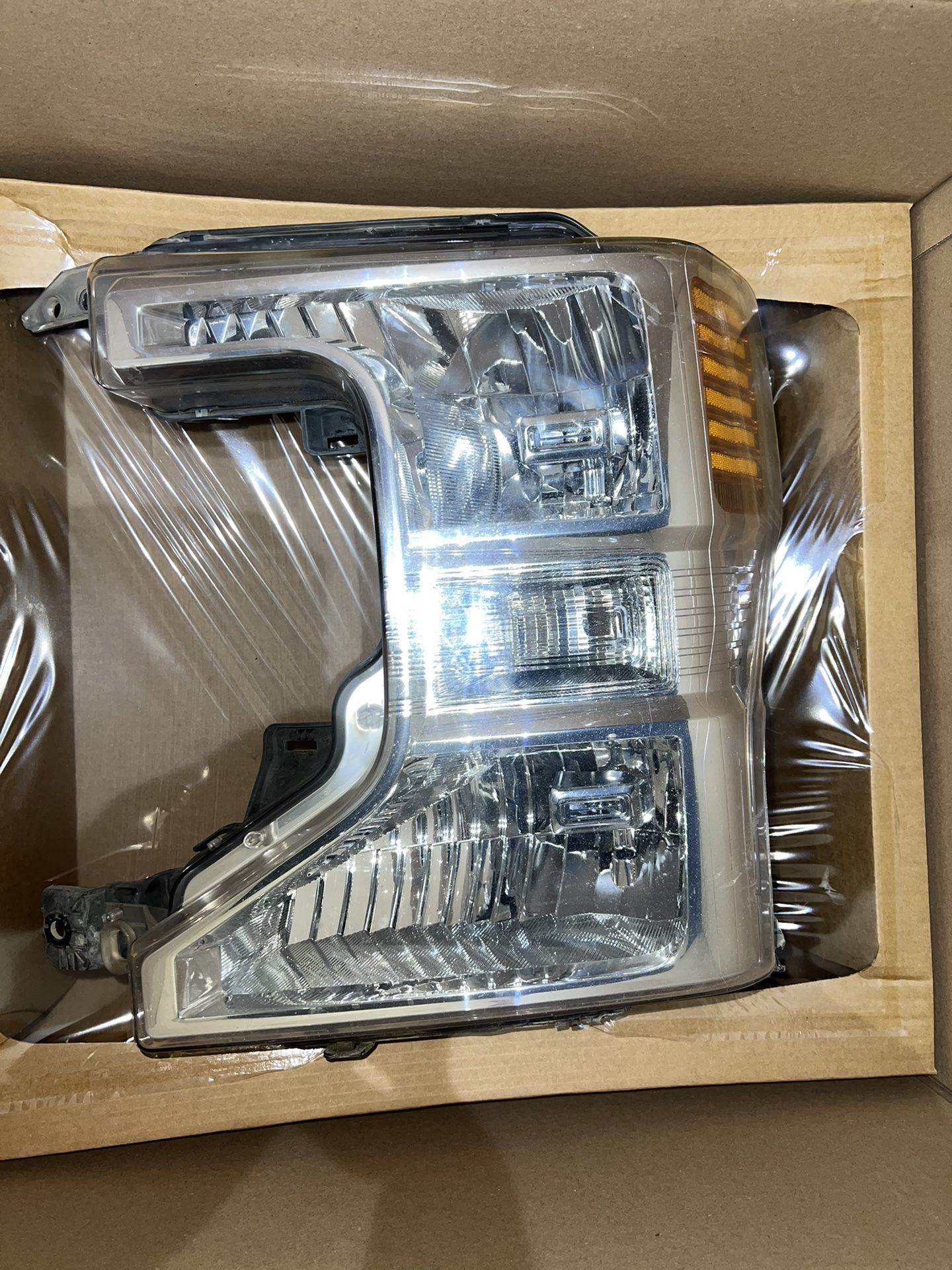 2020 F250 Left Hand Side Headlight Assembly. Has one tab missing on bottom corner and has a crack Pictures taken of damage 