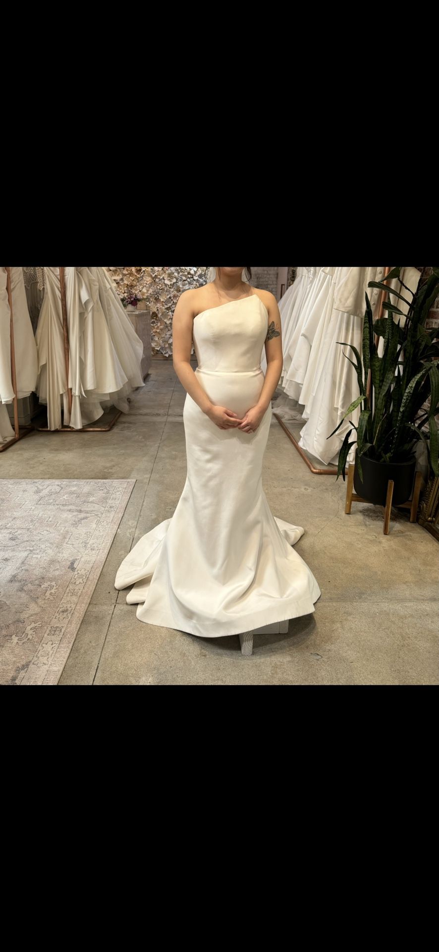 Romona Keveza Strapless gown made of silk crepe, features an asymmetrical neckline and a fluted skirt.