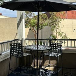 Bistro table W 2 Chairs And Black Umbrella