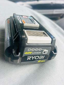 Powerful Ryobi 40V Lithium battery. It has a 2Ah capacity. Battery has a charge indicator with green lights. Black and yellow color scheme. The batter