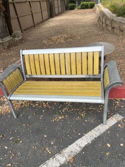 vintage outdoor metal-frame slat bench, likely aluminum or steel, with yellow/gold-painted wood or comp