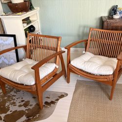 A Pair Of CB2 Noelie curved Rattan And Wood Armchairs