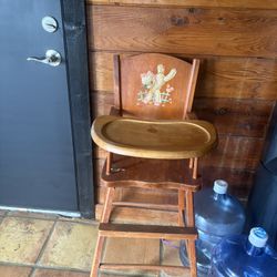 This is a vintage Lehman Babyguard wooden high chair featuring a cowboy puppy motif