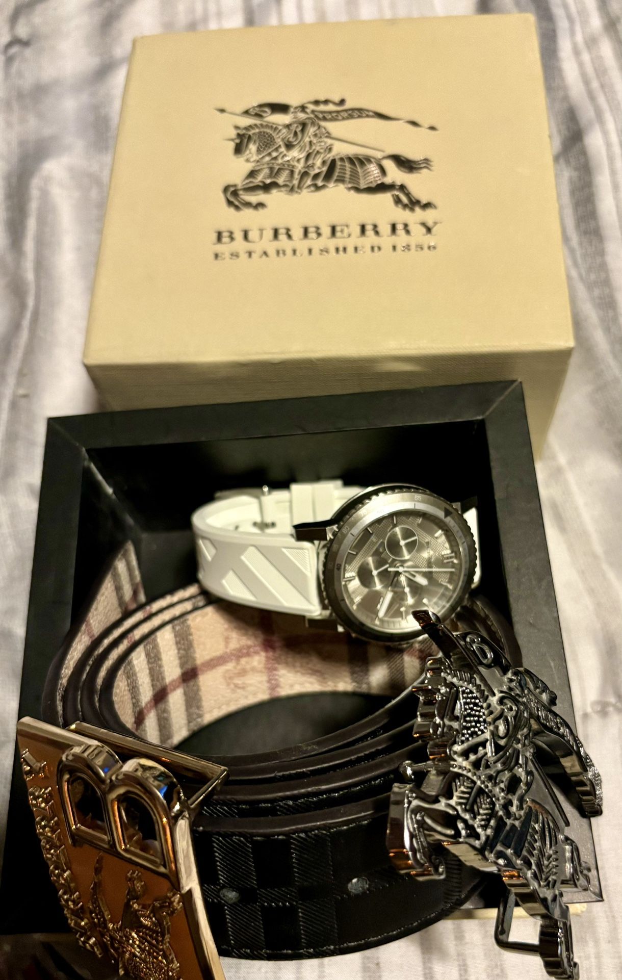 Brand new FIRM!! beautiful white band Burberry sapphire Crystal watch I think they’re going for around 700 and matching Burberry belt with two buckles
