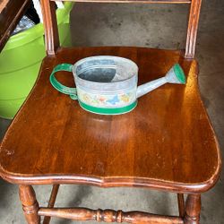 This is a galvanized metal watering can with a decorative design.