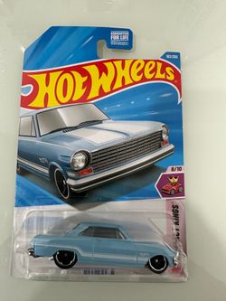 New Hot Wheels '63 Chevy II die-cast car in light blue. This 1:64 scale model is part of the Compact Kings series and has a chrome-colored base and bl