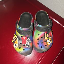 Crocs Classic Solarized Clogs in black/multicolor with added soccer-themed Jibbitz charms. 