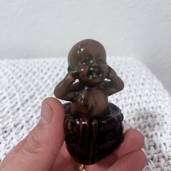 the figure of a boy in a bucket is hand-carved from resin
