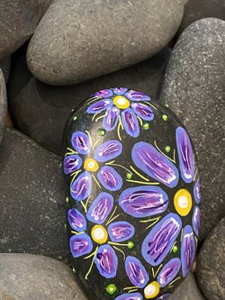 Purple flower painted rock with neon accents