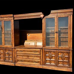 wood entertainment center or hutch with glass-paneled doors and lower cabinets.