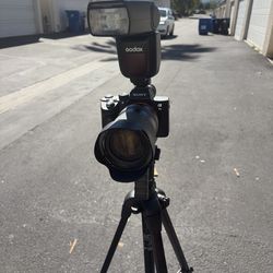 The item pictured is a Sony Alpha 7 III mirrorless camera equipped with a Godox flash