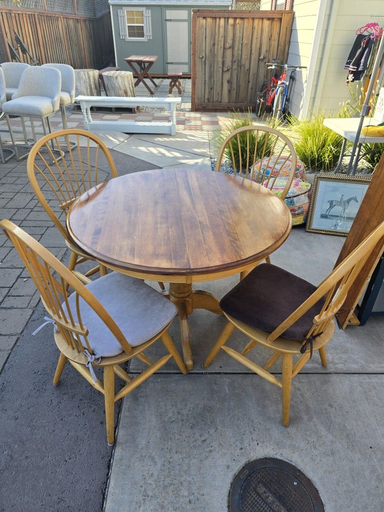 42 inch solid oak dining table and four chairs and multi colored seat cushions. Comes with qty 1: 10 inch leaf (extender)