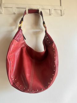 Stylish red hobo shoulder bag with gold-tone stud accents.