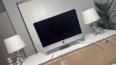 El ordenador central que aparece en la imagen es un iMac de Apple. Viene acompañado por sus accesorios oficiales: el teclado Magic Keyboard y el ratón