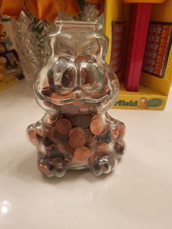 Garfield glass, piggy bank full of pennies, old $100. Mickey Mouse crystal from Disneyland is $60. All's perfect
