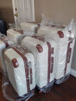 New White Hardshell Luggage Set with Brown Trim each set is $85