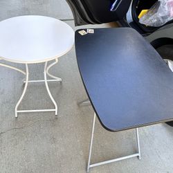 Two foldable small tables, one black and one white. The black table has scratches. The two tables are sold together for $10.