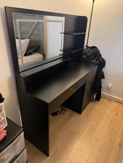 Black vanity with lights and leather chair