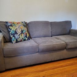 Gray couch with two gray pillows