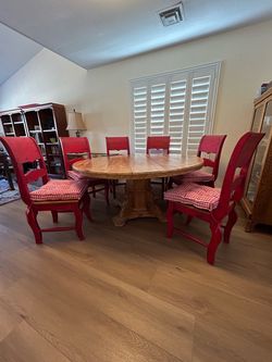 Round rustic farmhouse dining room table with six chairs