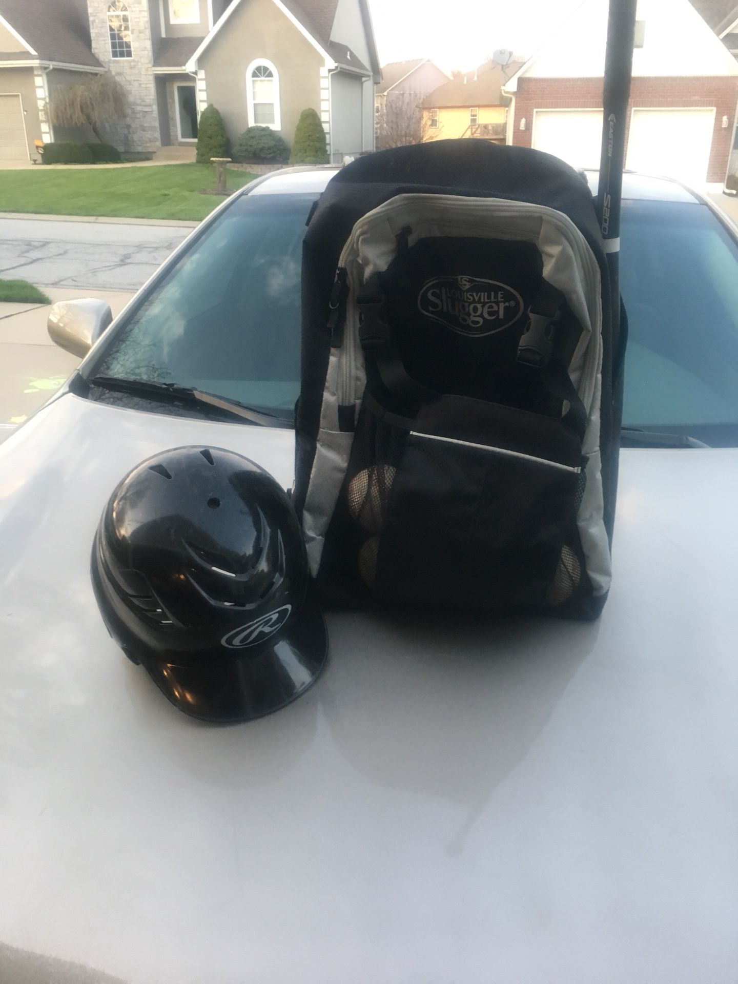 Kids helmet and backpack and baseballs and bat