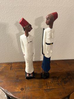Vintage collectibles West African hand-carved colonial statues, often referred to as "Colon" figures.