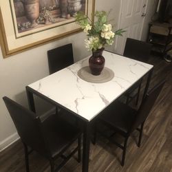 White faux marble dining table set with 4 dark brown leather chairs