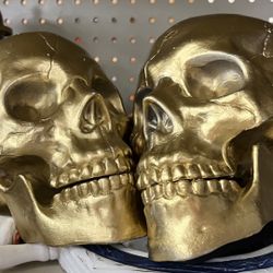 Two gold skull decorations 