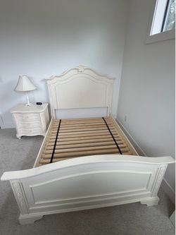 White full size bed and a matching nightstand