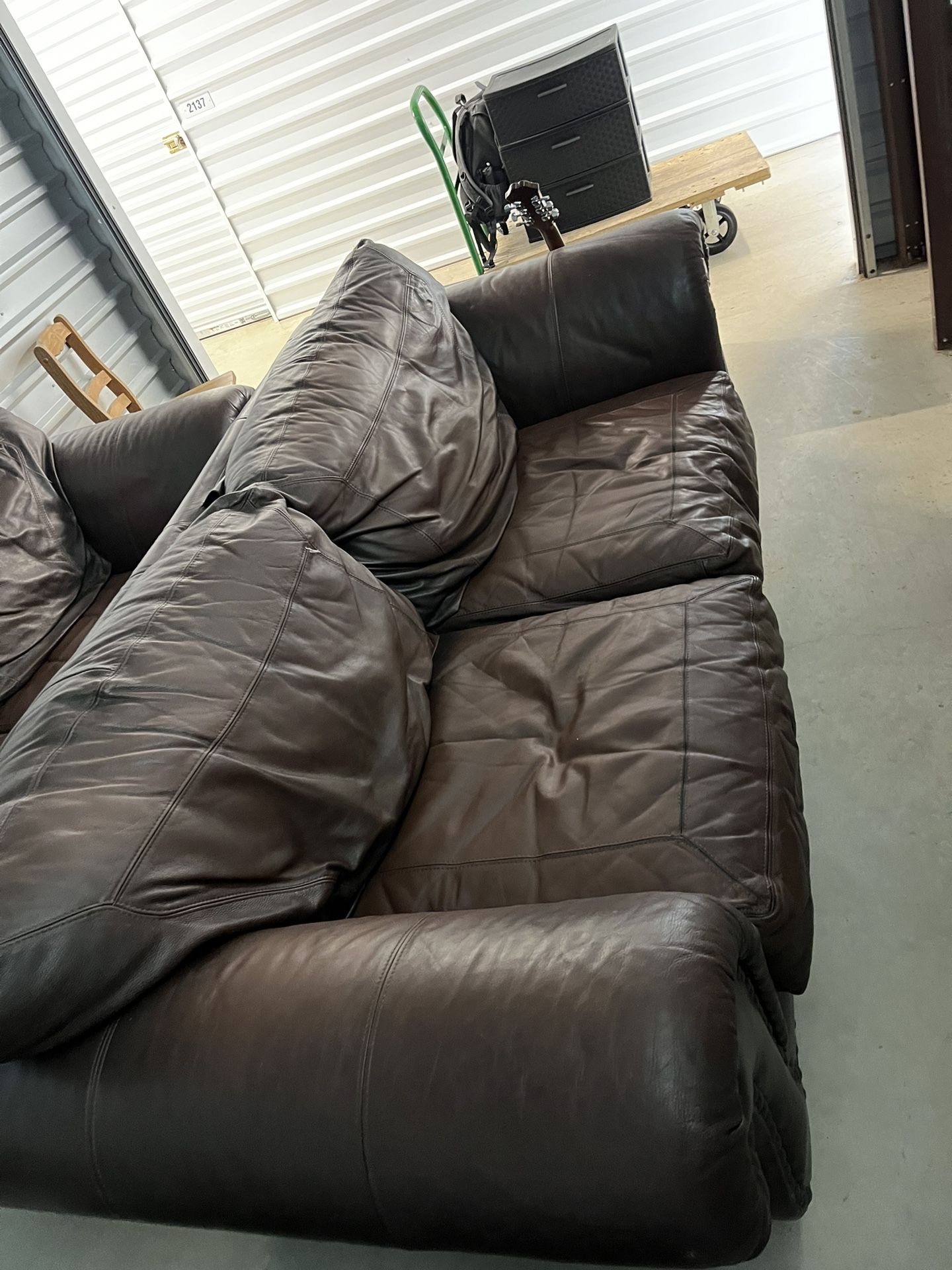 Two leather couches with a leg rest